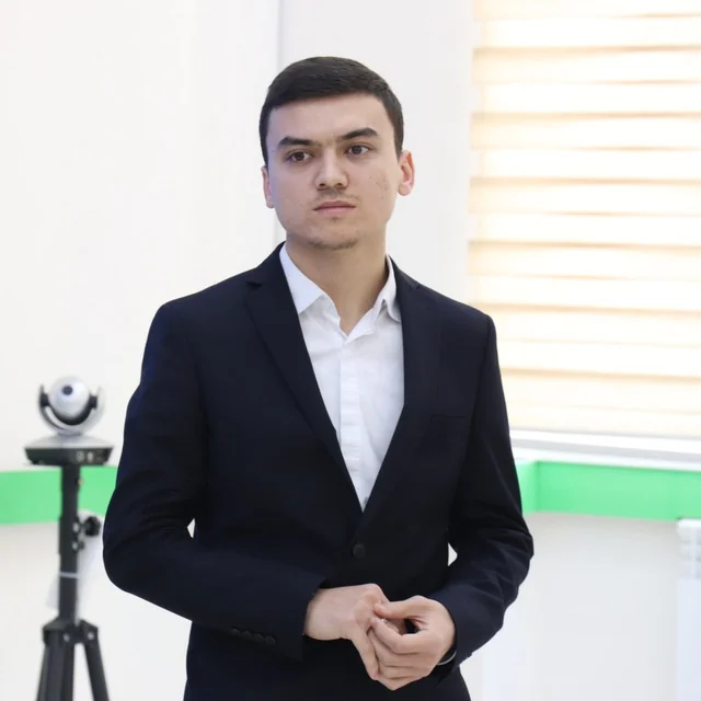 Muhammad Amin Naziraliyev kostyumda, Codial akademiyasi o'quv xonasida